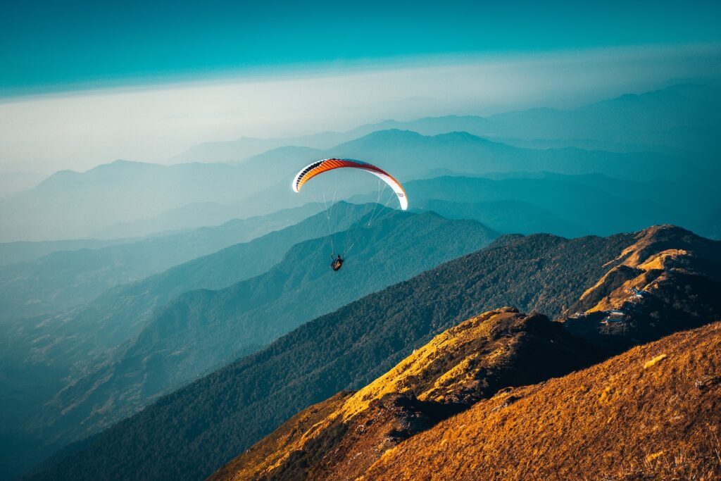 A person paragliding over hills